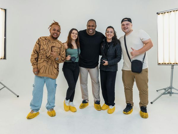 A diverse group of people smiling in a yoga studio setting.